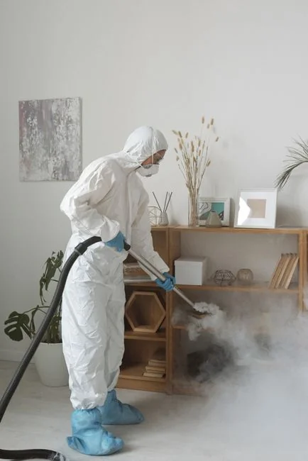 services-04 Close-up of a person vacuuming a modern sofa chair indoors, highlighting cleaning service.